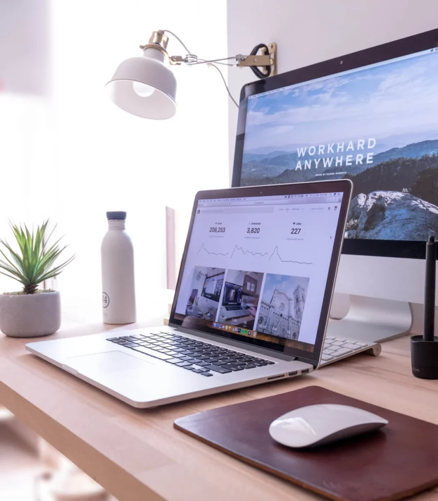 A desktop and laptop computers on a desk showing work from home set up.