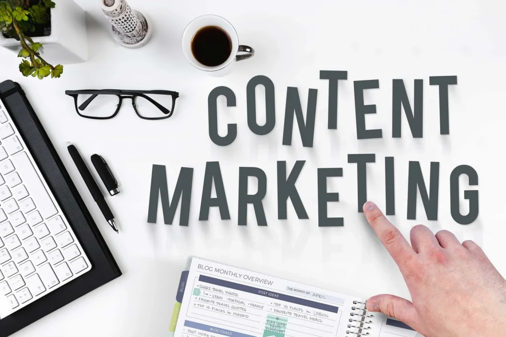 White desk with various items and the words "content marketing" spelled out.