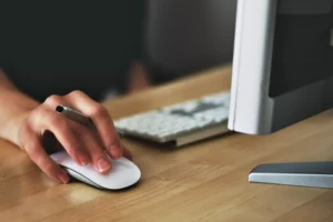 Someone working on the computer using the mouse.